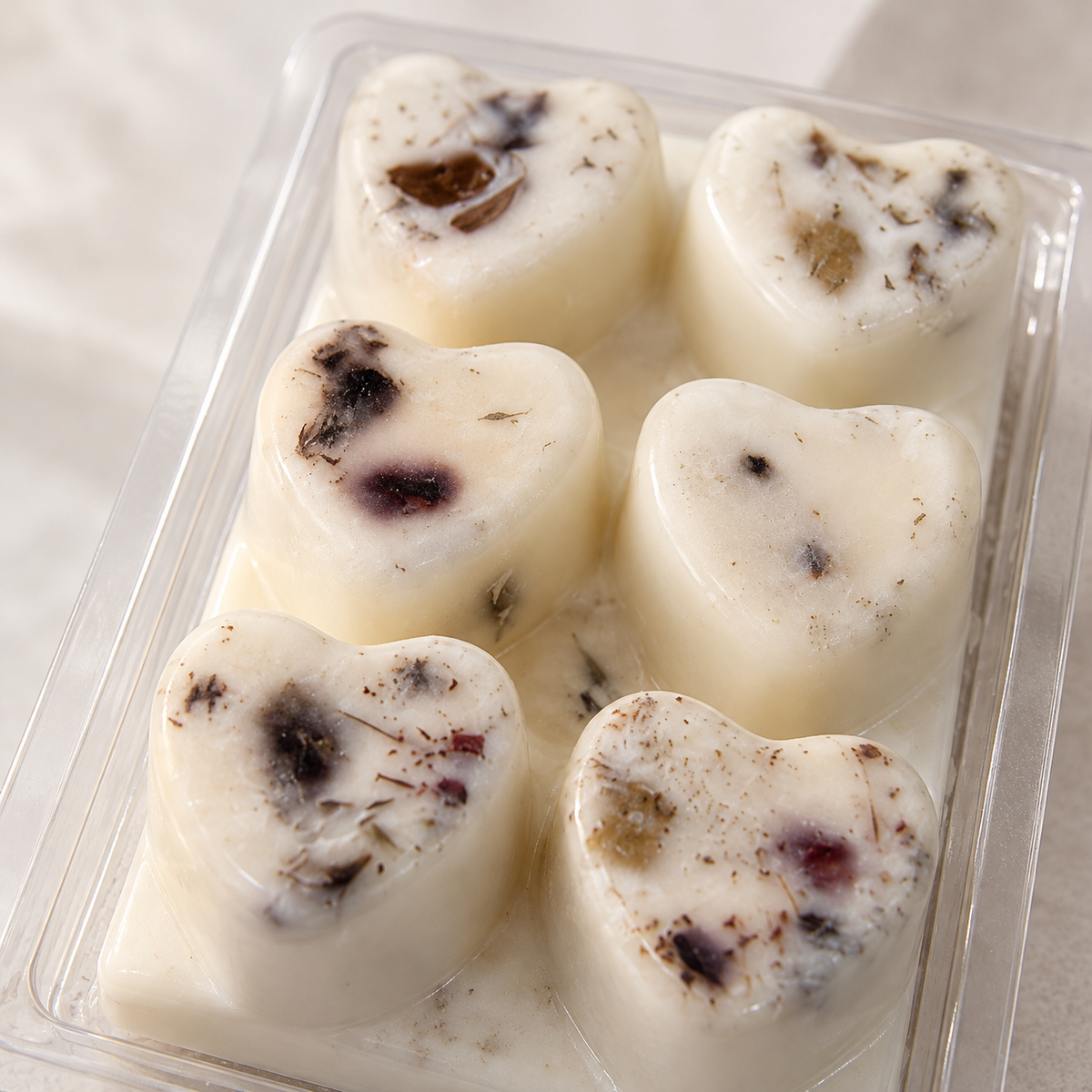 Close-up van handgemaakte sojawas waxmelts in hartvorm met gedroogde bloemen en kruiden